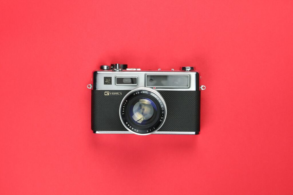 A camera rests on a red backdrop