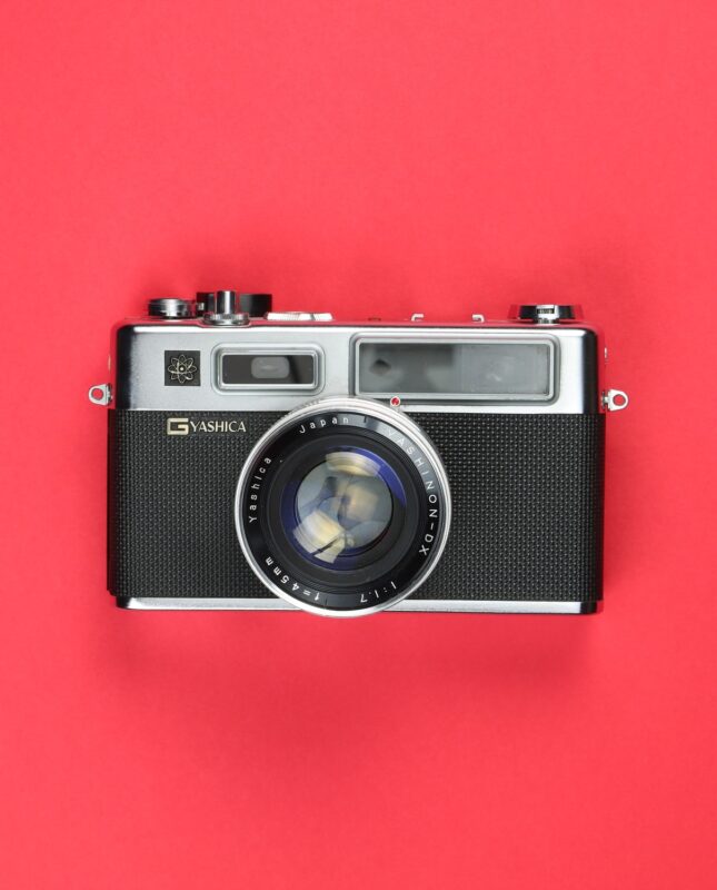 A camera rests on a red backdrop