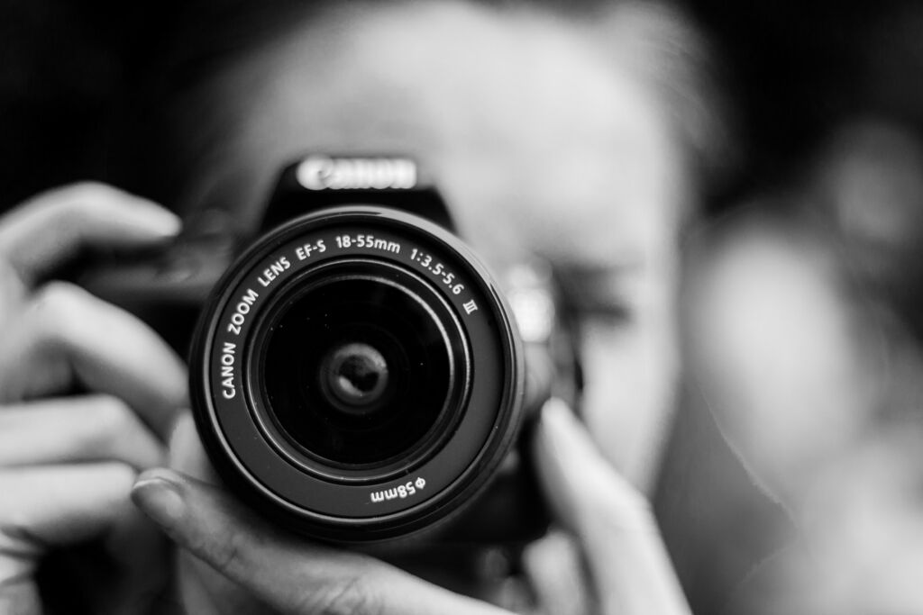 A person with a camera focuses on taking a picture.