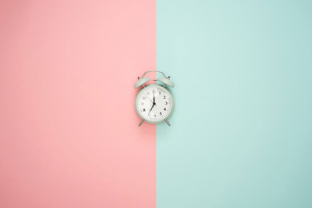 clock on a pink and blue background