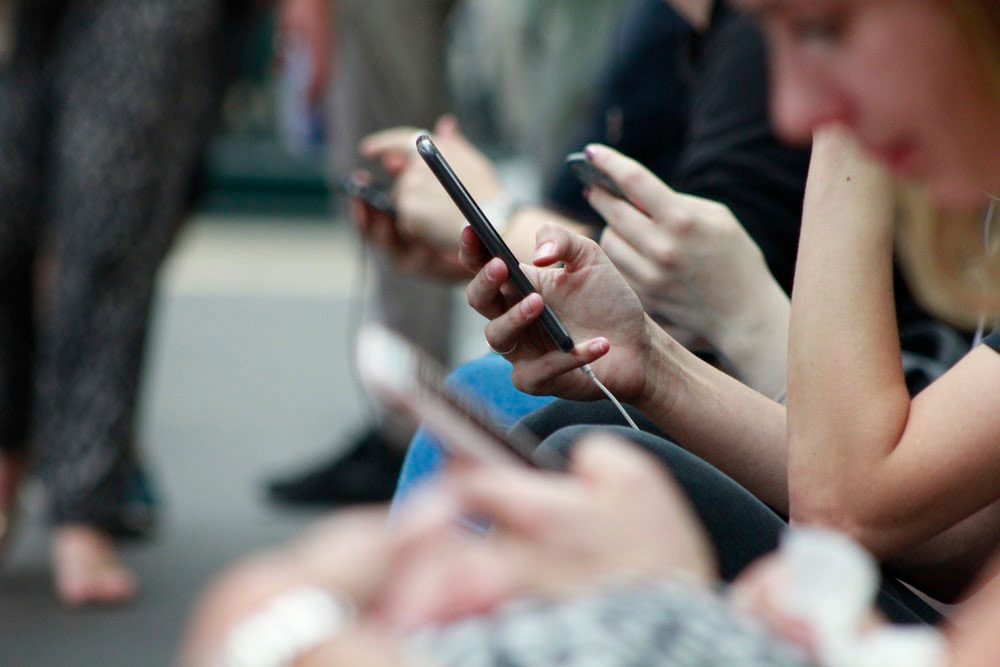 people engaging in social media on their phones