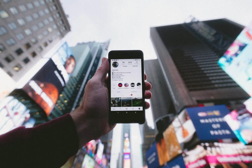 person holding phone towards the sky