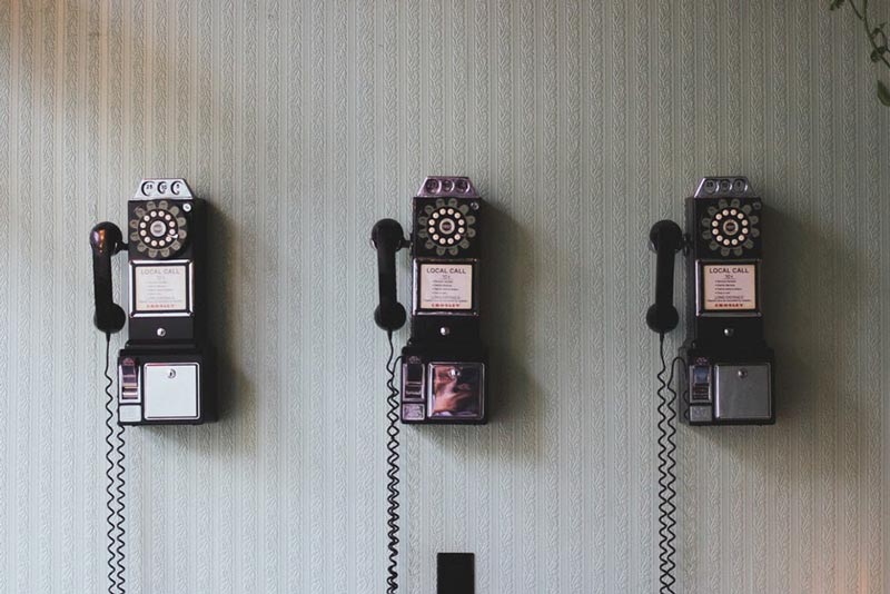 line of three antique phones